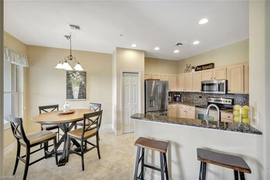 Kitchen featuring a breakfast bar, appliances with stainless steel finishes, backsplash, dark stone counters, and a peninsula