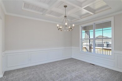 Carpeted spare room featuring visible vents, crown molding, beam ceiling, a notable chandelier, and coffered ceiling