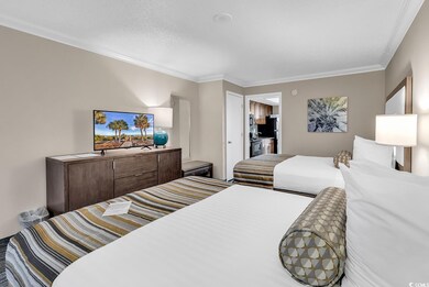 Bedroom with ornamental molding and black fridge