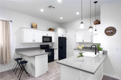 Kitchen featuring a peninsula, a breakfast bar area, wood tiled floors, and recessed lighting