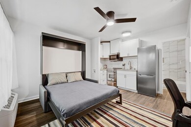 Bedroom with freestanding refrigerator, a sink, l