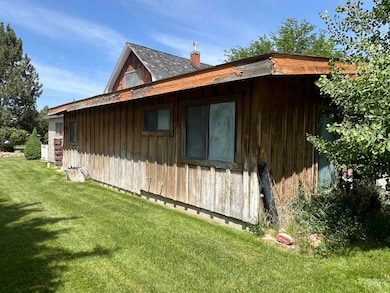 View of home's exterior featuring a yard and a chimney