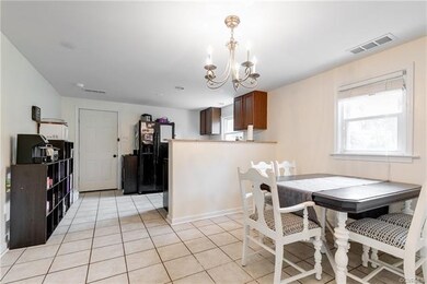 The kitchen has tile flooring and a chandelier.