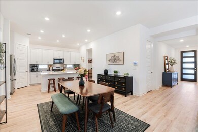 Dining area with recessed lighting and light wood