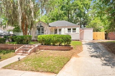 Front of newly painted house with new brick walkway stairs and driveway with extra parking pad.