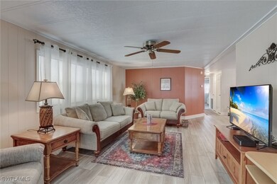 Living room with crown molding, ceiling fan, a hea