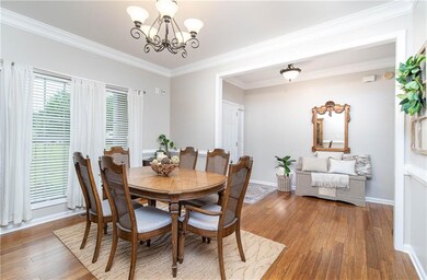 Dining area featuring a chandelier, bamboo hardwoods, crown molding, and baseboards