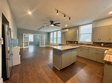Kitchen with stainless steel fridge, dark hardwood