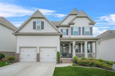 Craftsman-style home featuring covered porch, a garage, concrete driveway, and brick siding