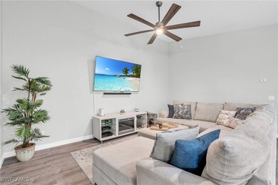Living area with wood finished floors, ceiling fan
