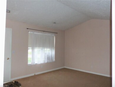 Roomy living room with neutral dcor and vaulted ce