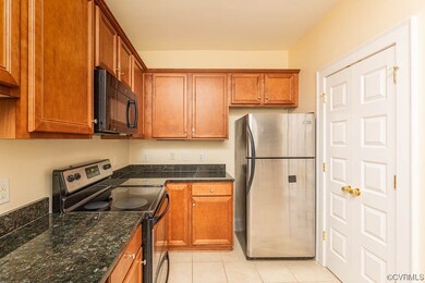 Kitchen featuring dark stone countertops, stainles