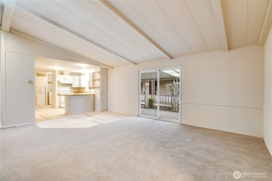 This view highlights the open floor plan—ideal for entertaining or everyday living. Sliding glass doors lead directly to the covered carport for easy access.