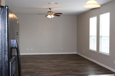 Empty room with ceiling fan, dark wood-type floor