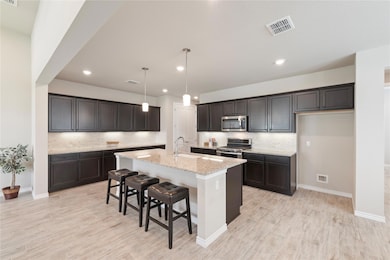 Kitchen with light stone countertops, backsplash,
