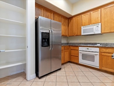 Kitchen featuring white appliances, light tile pat