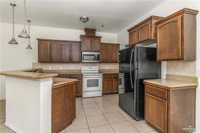 Kitchen featuring white range with electric cooktop, stainless steel microwave, tasteful backsplash, and freestanding refrigerator