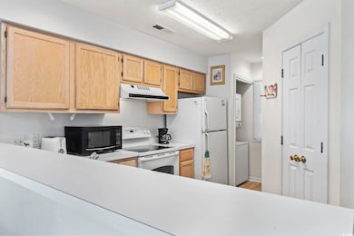 Kitchen featuring white appliances, visible vents,