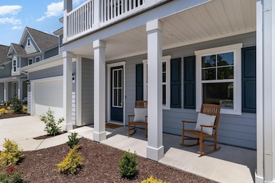 Doorway to property featuring a porch and a garage