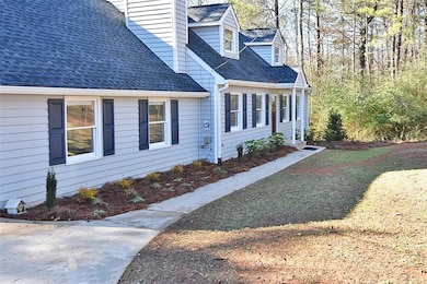 View of side of home featuring a chimney and a shingled roof