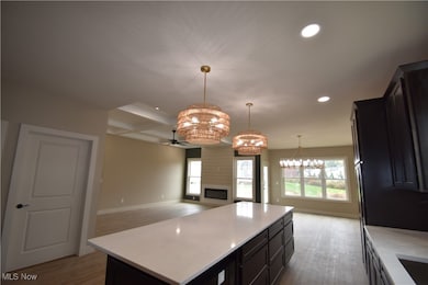Kitchen featuring open floor plan, recessed lighting, a center island, coffered ceiling, and beam ceiling