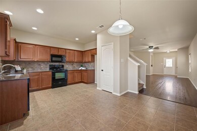 Kitchen with visible vents, a sink, black applianc