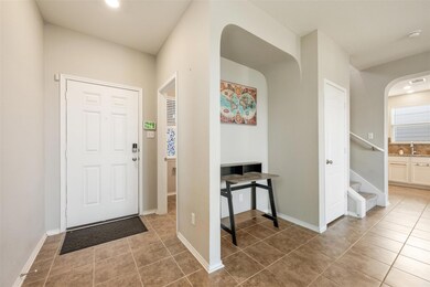Tiled entryway featuring arched walkways, stairwa