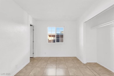 Spare room with light tile patterned flooring and baseboards