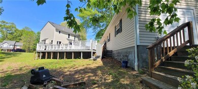 Deck behind detached garage next to lake