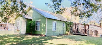 View of side of home featuring a lawn and a wooden