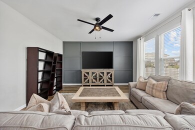 Living room featuring ceiling fan and dark hardwoo