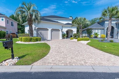 Mediterranean / spanish home with a garage, a front yard, driveway, and stucco siding