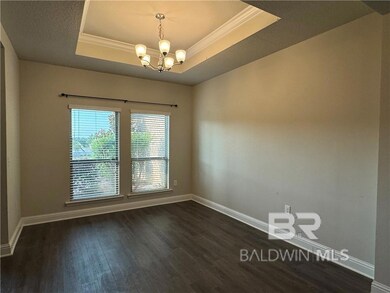 Unfurnished room featuring an inviting chandelier, dark wood-type flooring, and a tray ceiling