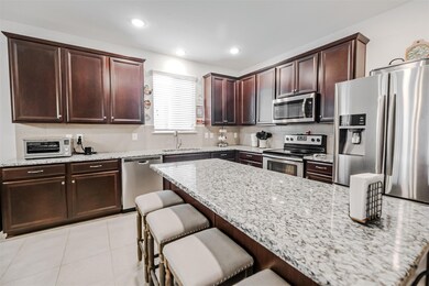 Kitchen featuring light stone counters, light tile