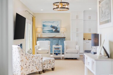 Sitting room featuring light hardwood / wood-style floors, a chandelier, and ornamental molding