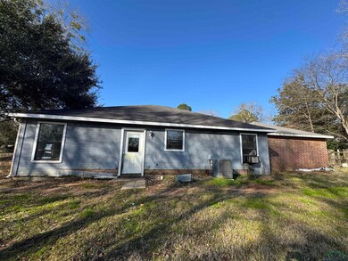 Rear view of property with central AC and a yard