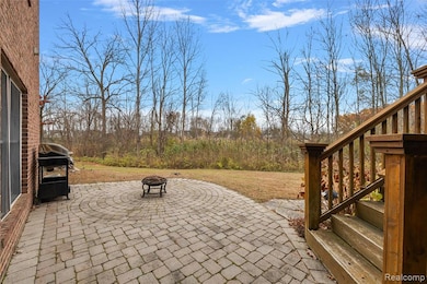 View of patio with an outdoor fire pit and area for grilling