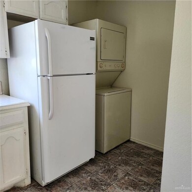 Laundry area featuring stacked washing machine and dryer
