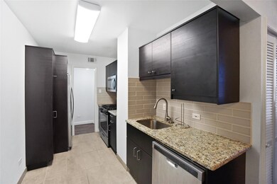 Kitchen with tasteful backsplash, light stone countertops, appliances with stainless steel finishes, light tile patterned flooring, and modern cabinets