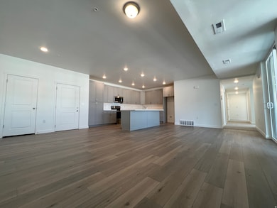 Unfurnished living room featuring dark wood-style floors and recessed lighting