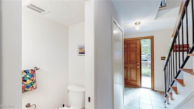 View from LR down hallway w/half bath w/pocket door & stairway to 2nd level