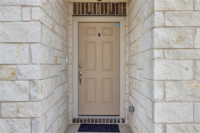View of exterior entry featuring stone siding