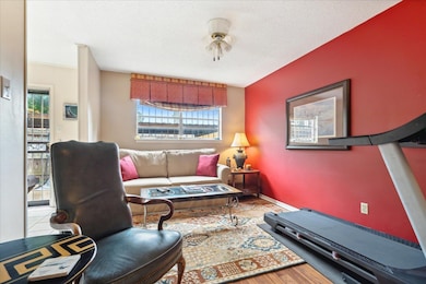 Interior space with a textured ceiling, hardwood / wood-style flooring, and ceiling fan