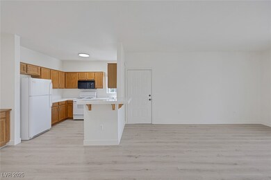 Kitchen featuring white appliances, a peninsula, l