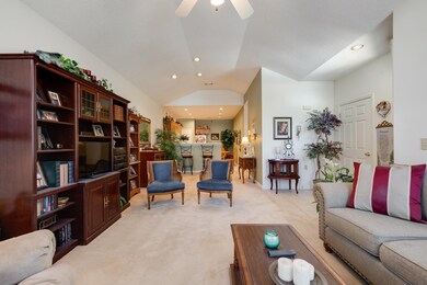 Living room with vaulted ceiling, light carpet, recessed lighting, a ceiling fan, and baseboards