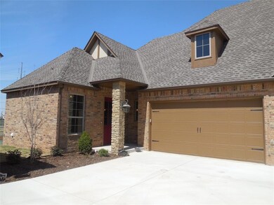 View of front of property featuring brick siding, roof with shingles, concrete driveway, and a garage