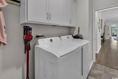 Laundry area with washer and dryer, cabinet space, and baseboards