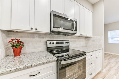 Beautiful white cabinets and gleaming granite countertops pair perfectly with the stainless steel appliances for a timeless look.