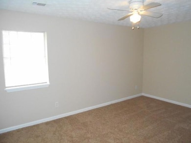 Carpeted empty room featuring visible vents, ceili