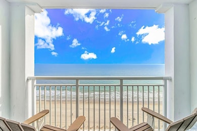 Balcony featuring a water view and a beach view